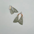 Pair of moth-shaped earrings on a light gray background