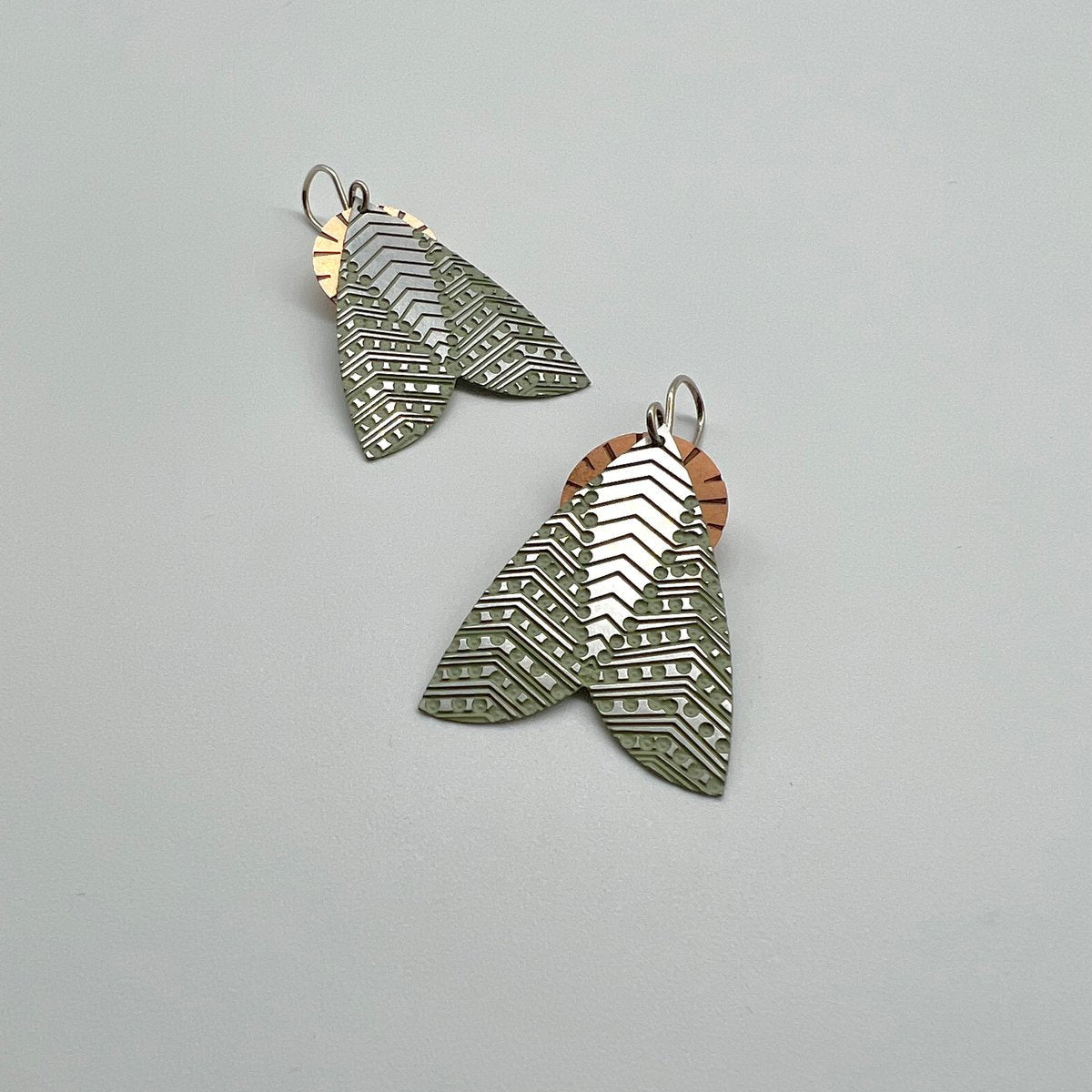 Pair of moth-shaped earrings on a light gray background